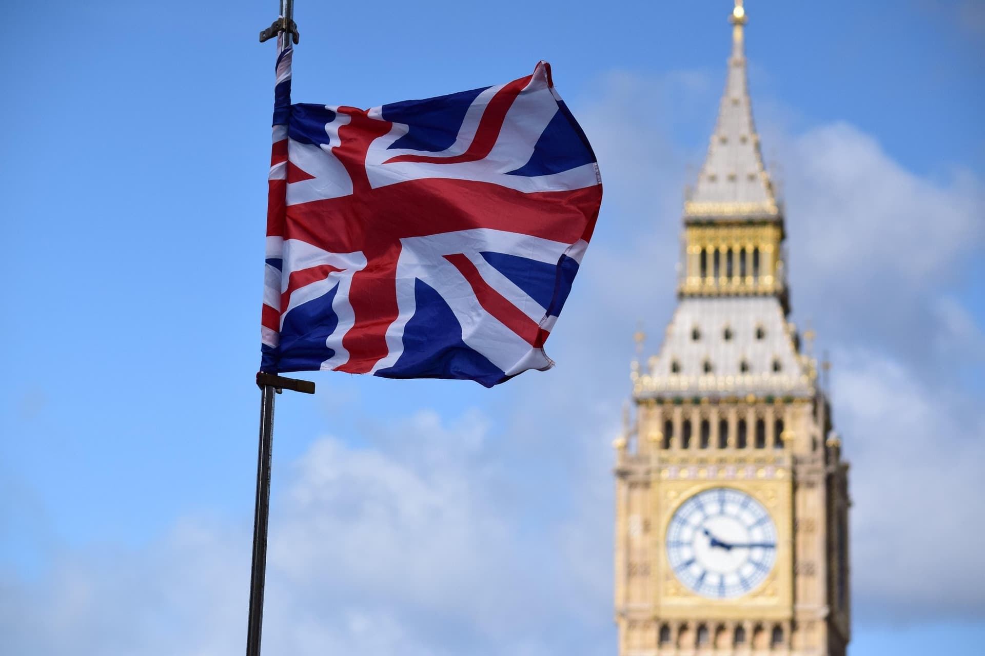 A flag of Great Britain with the background of a beatiful building