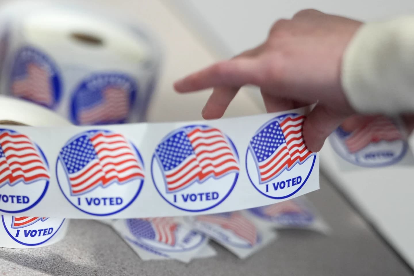 A worker tearing off "I Voted" stickers during the Virginia redistricting referendum